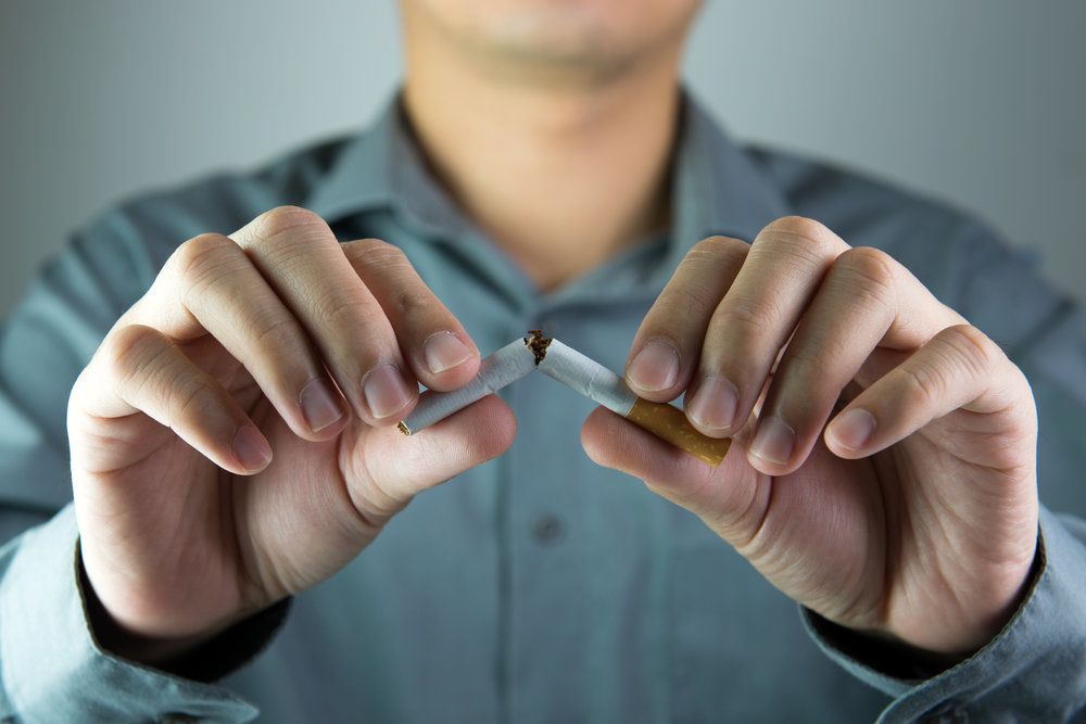 Man breaking a cigarette in half
